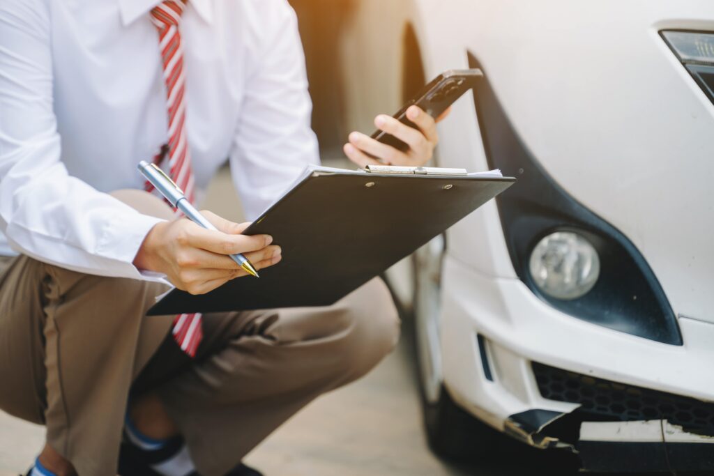 person inspecting car and looking at phone